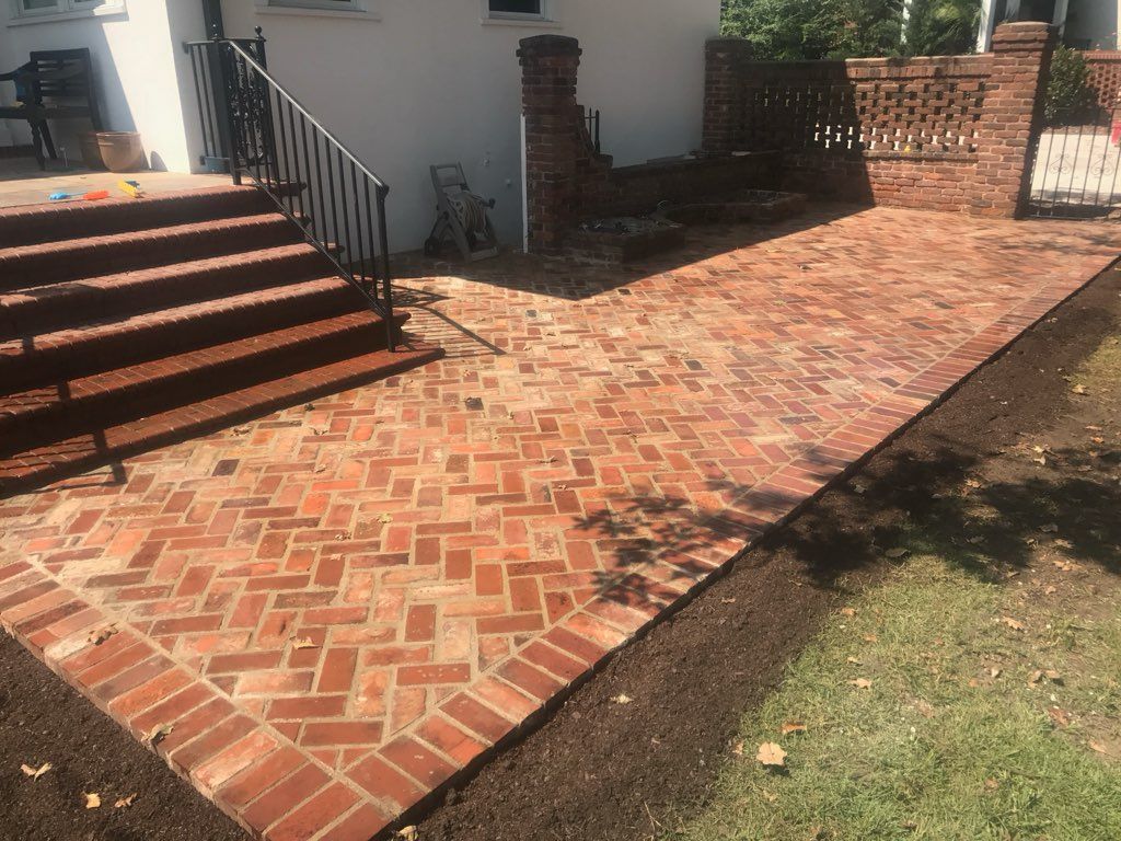 A brick walkway with stairs leading up to a house.