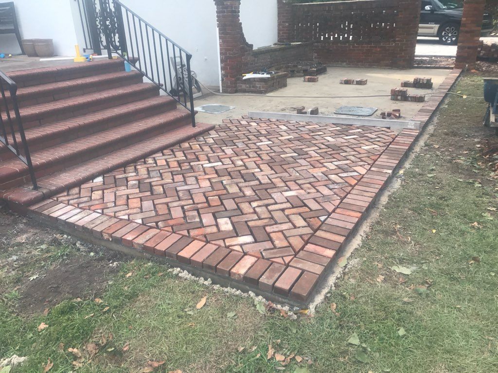 A brick walkway is being built in front of a house.