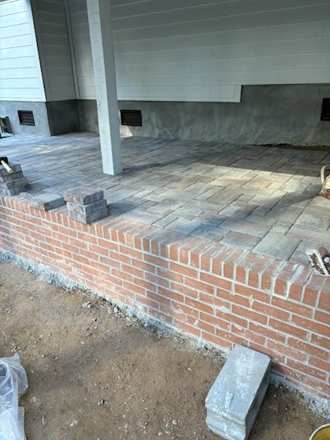 A brick wall is being built on the side of a house.