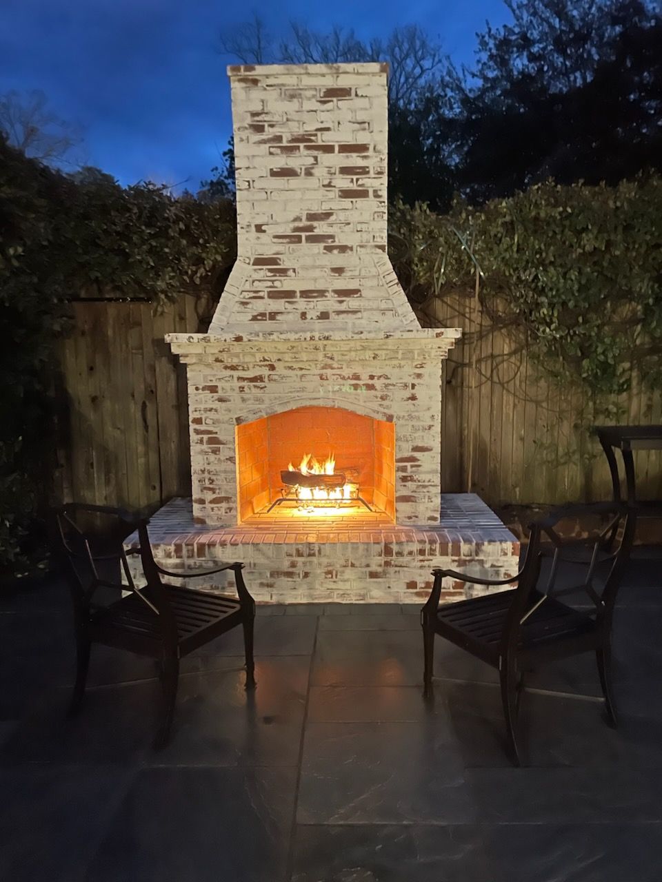 A brick mailbox is sitting on top of a brick pillar.