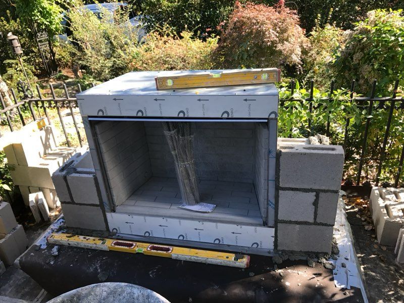A fireplace is being built with bricks and a level.