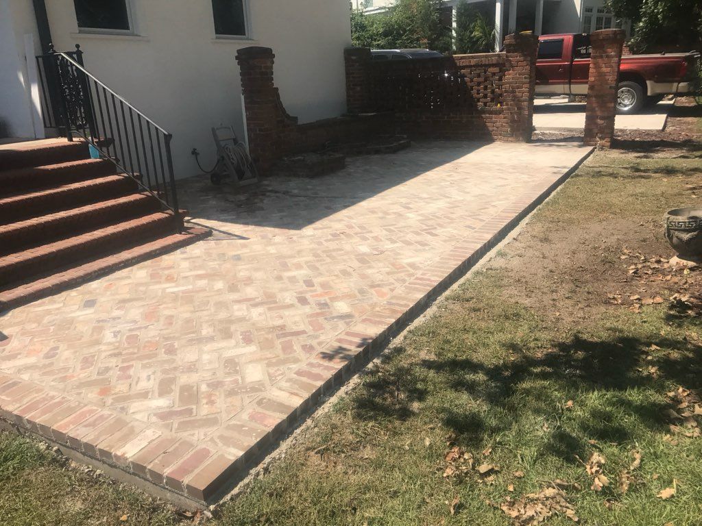 A brick walkway is being built in front of a house.