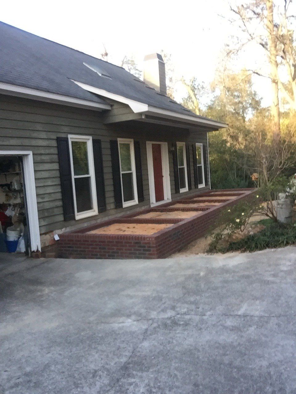 A house with a garage and a brick walkway in front of it.