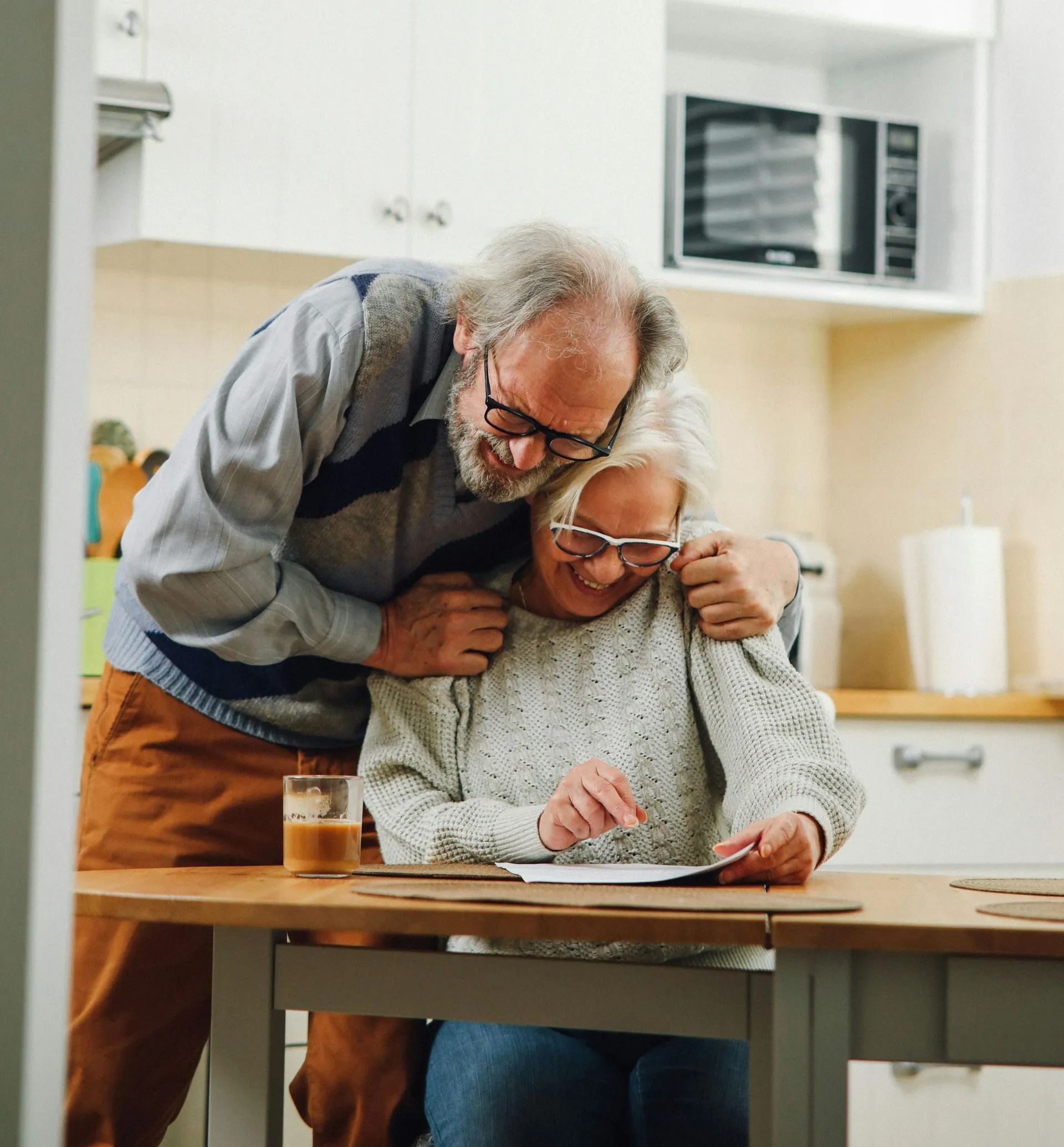 An elderly couple is dancing at a table in a restaurant.