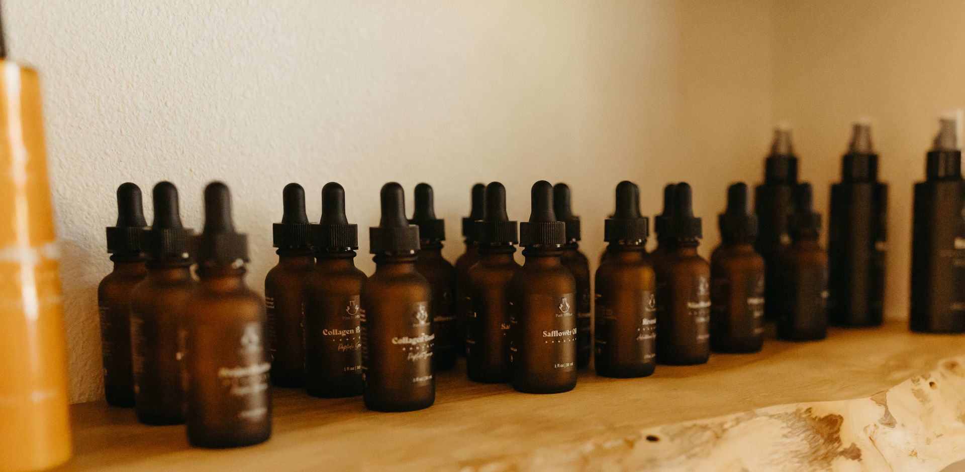 Four brown skincare product bottles with white caps and dispensers.