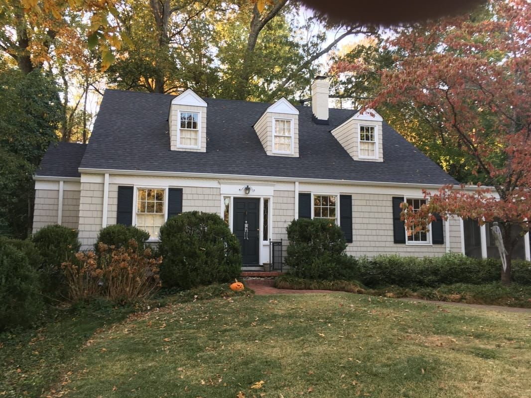 A white house with a black roof and black shutters