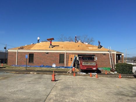 A group of people are working on the roof of a building.