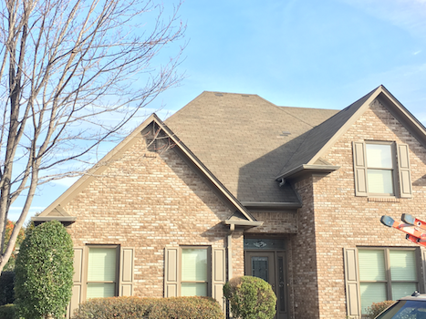 A large brick house with a car parked in front of it.
