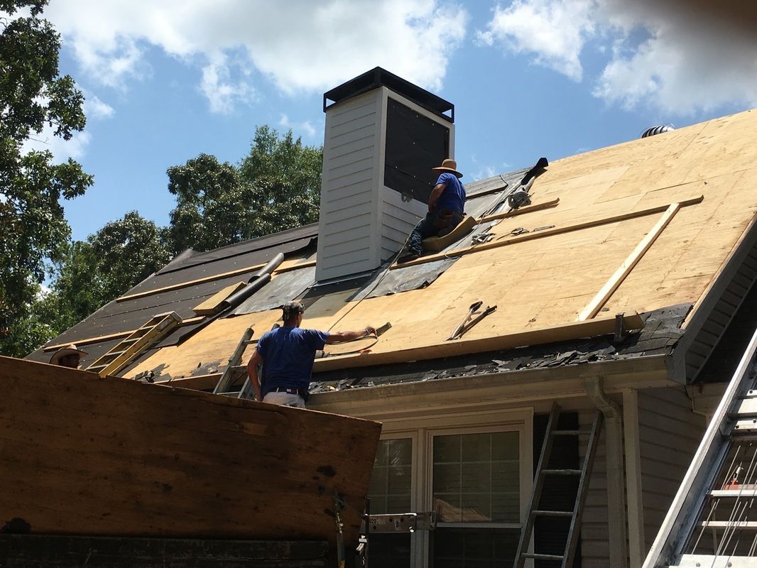 Two men are working on the roof of a house
