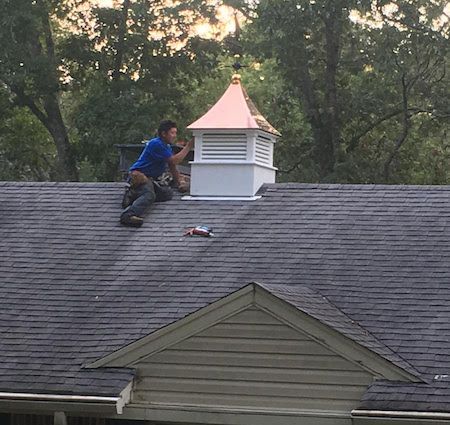 A man is working on the roof of a house.