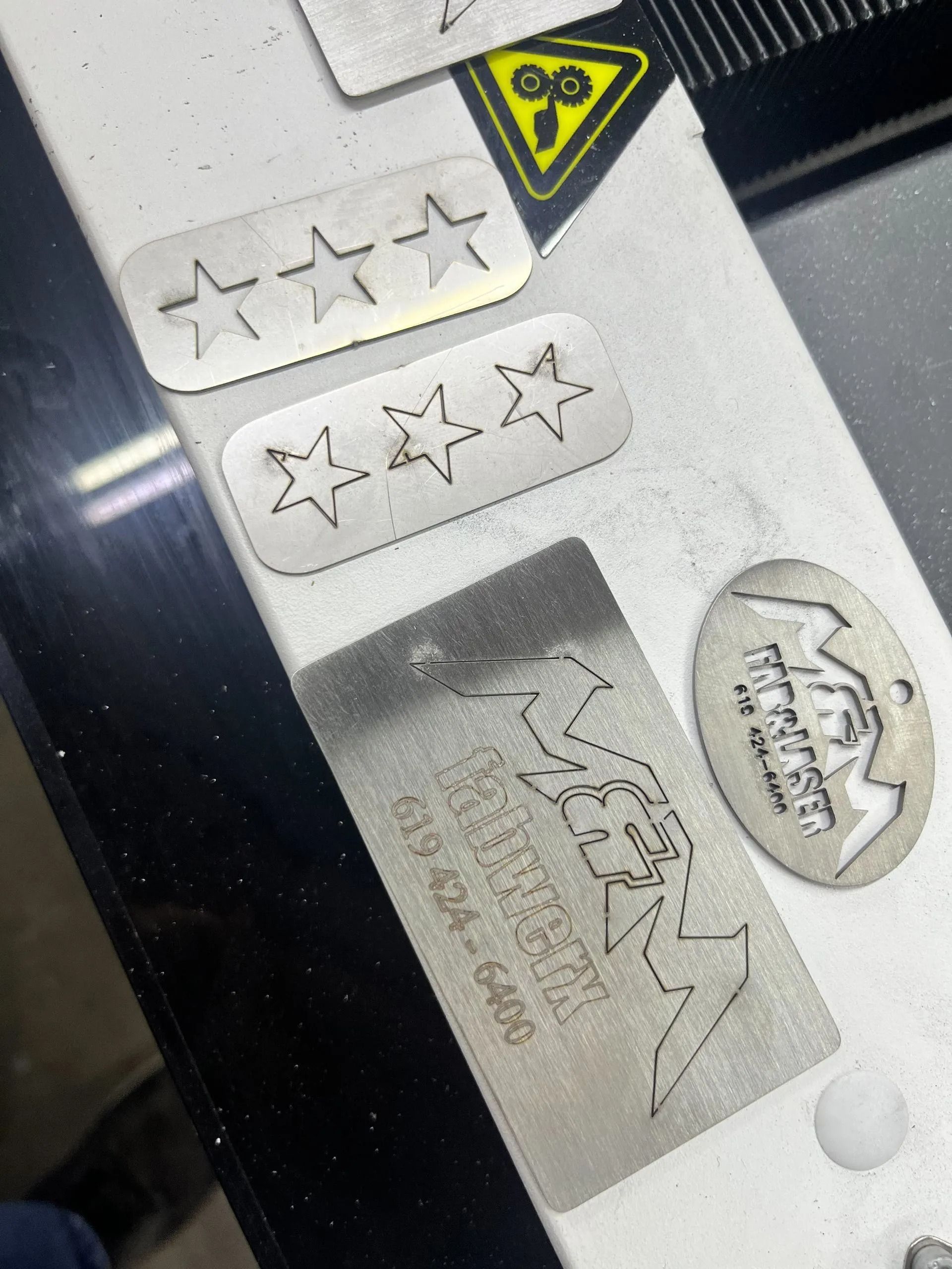 A few pieces of metal are sitting on a table and one of them says ' biker buzz ' on it