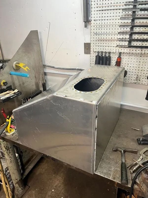 A metal box is sitting on top of a metal table.