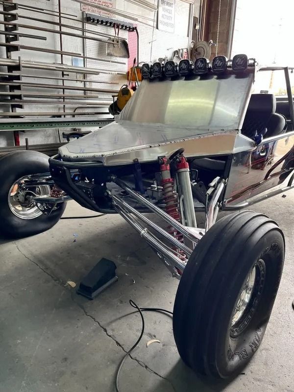 A buggy is sitting on the ground in a garage.