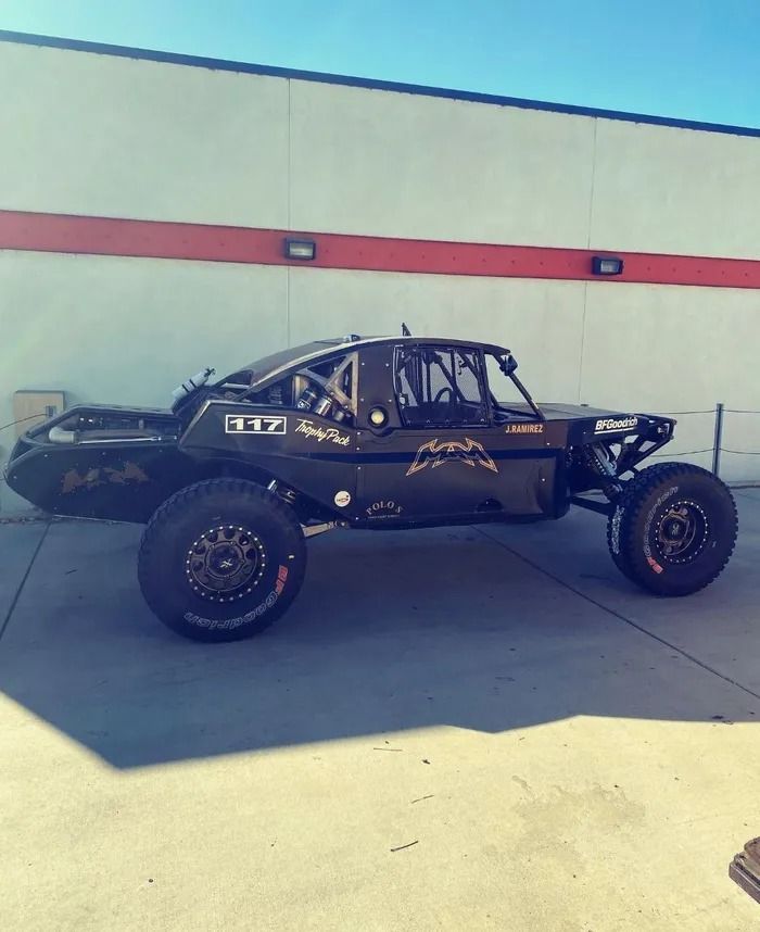 A black vehicle with the number 337 on the side is parked in front of a building