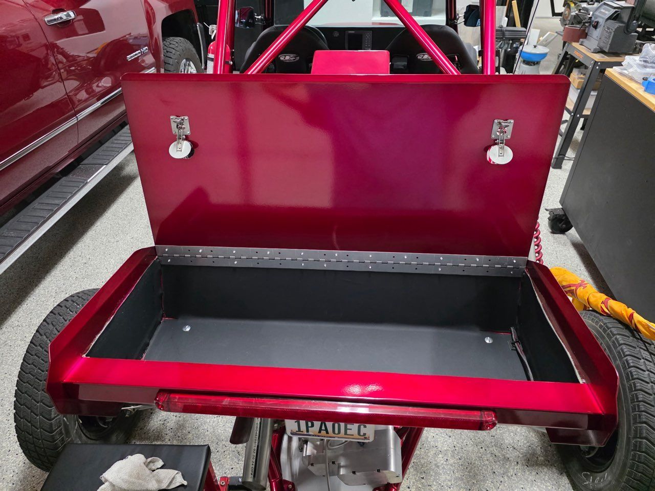 Red off-road vehicle with an open storage box, showing the interior.