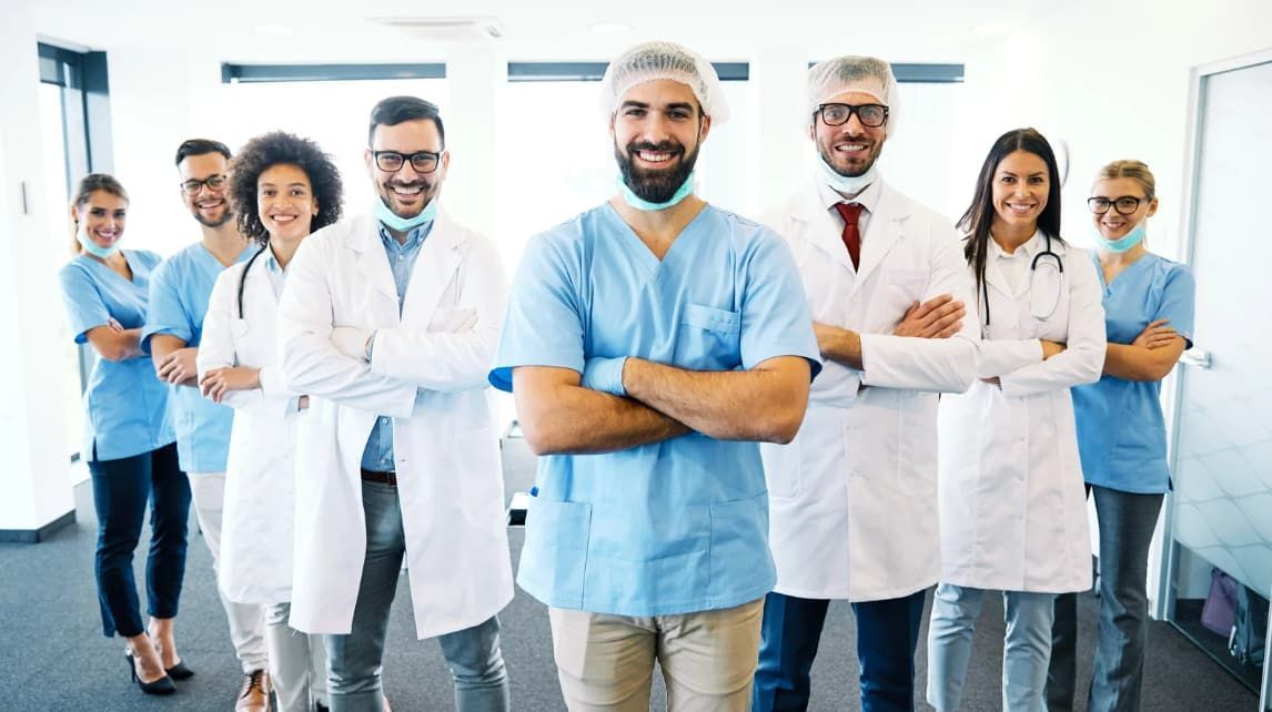 A group of doctors and nurses are posing for a picture in a hospital.