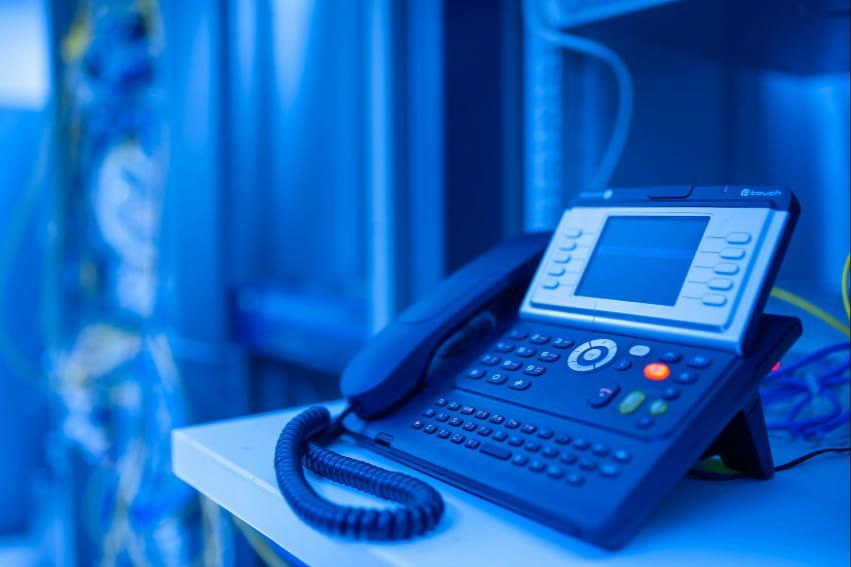 A telephone is sitting on a table in a server room.