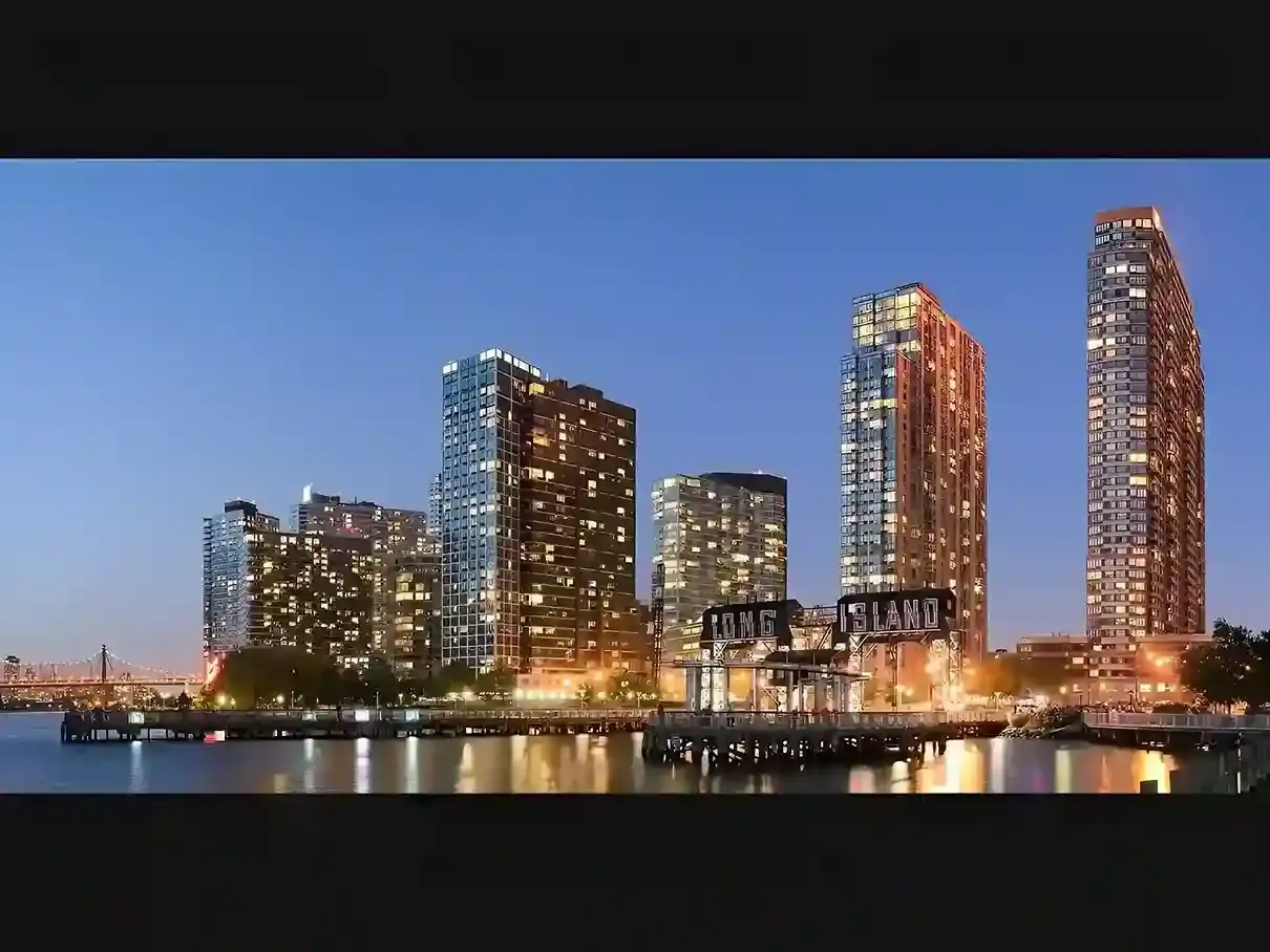 Long Island waterfront at night with lit buildings and the bright Long Island sign.