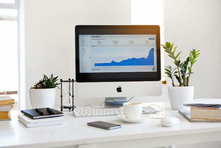 A computer monitor is sitting on top of a white desk.