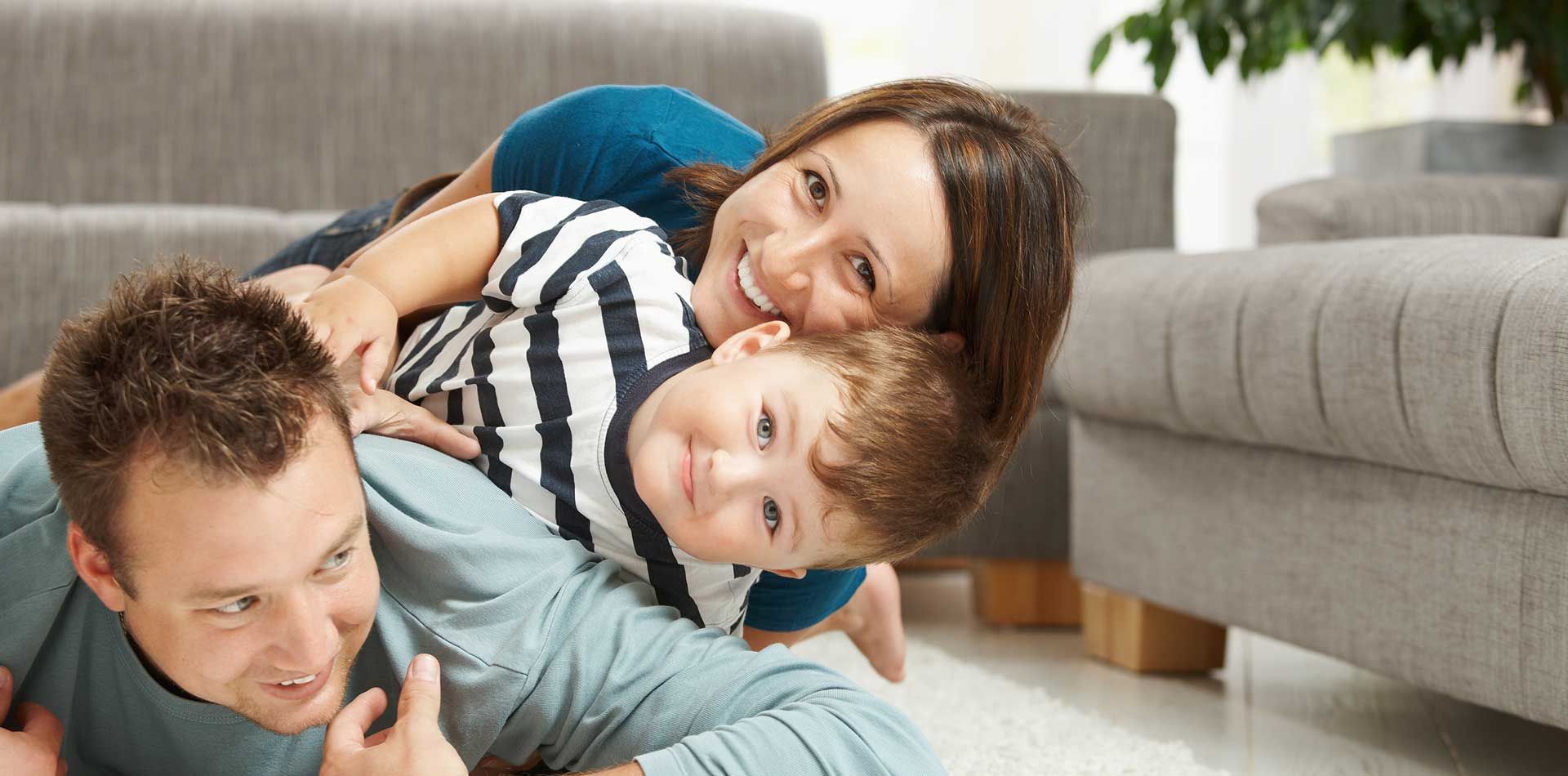 A family is laying on the floor in a living room.