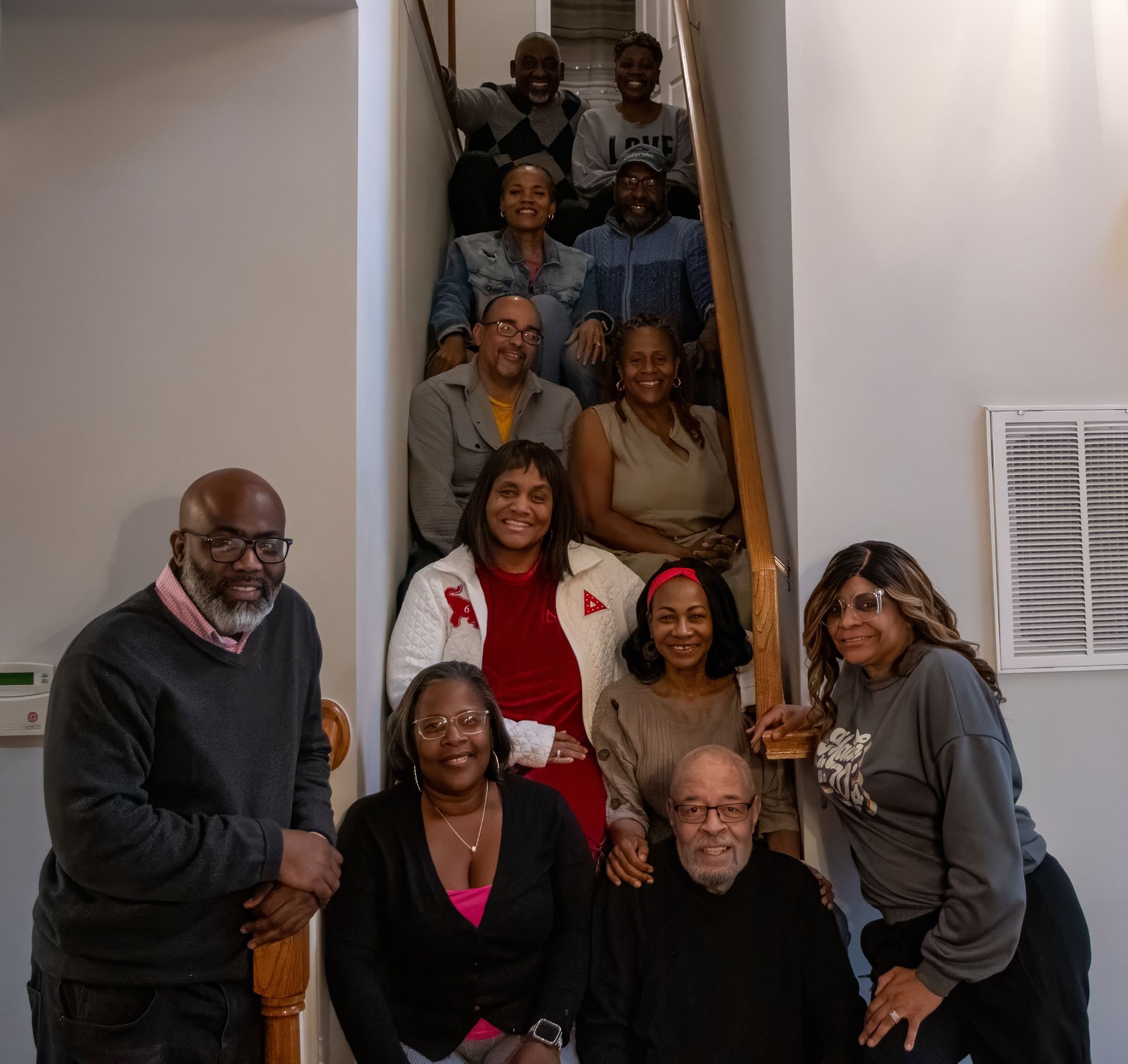 A large group of people posing for a photo on an indoor staircase.