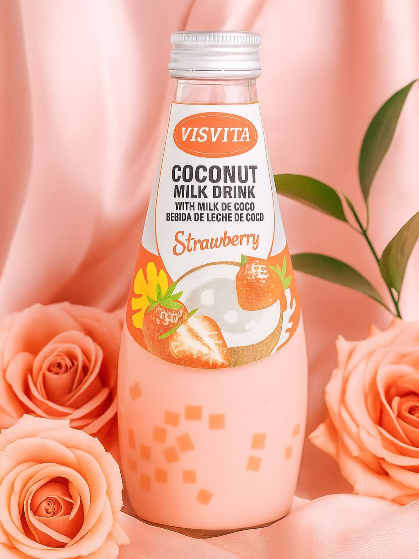 Bottle of Visvita strawberry coconut milk drink surrounded by roses, on a pink satin background.
