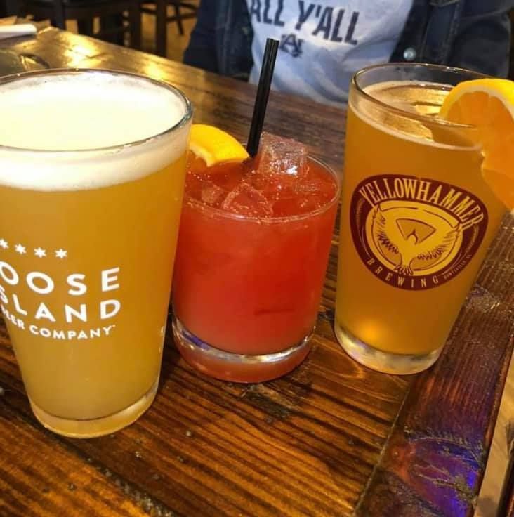A plate of food and a glass of beer on a table.
