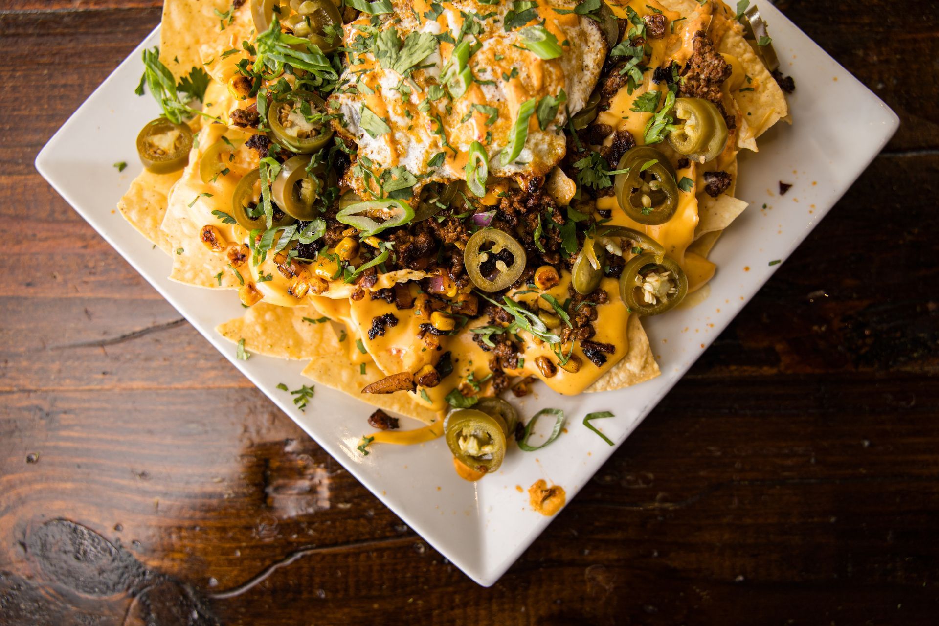 A close up of a plate of food with a drink in the background