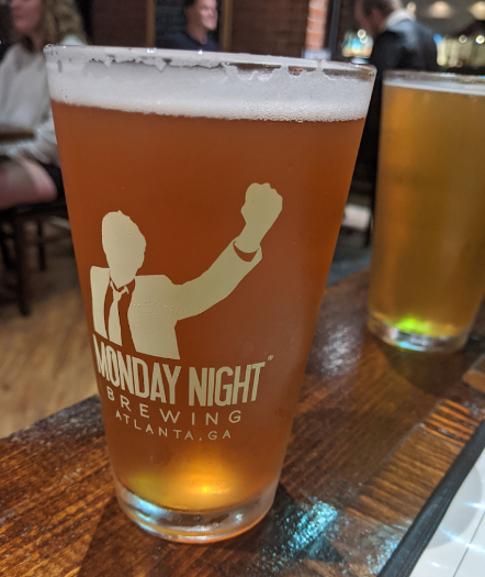Two drinks are sitting on a wooden table in a restaurant.