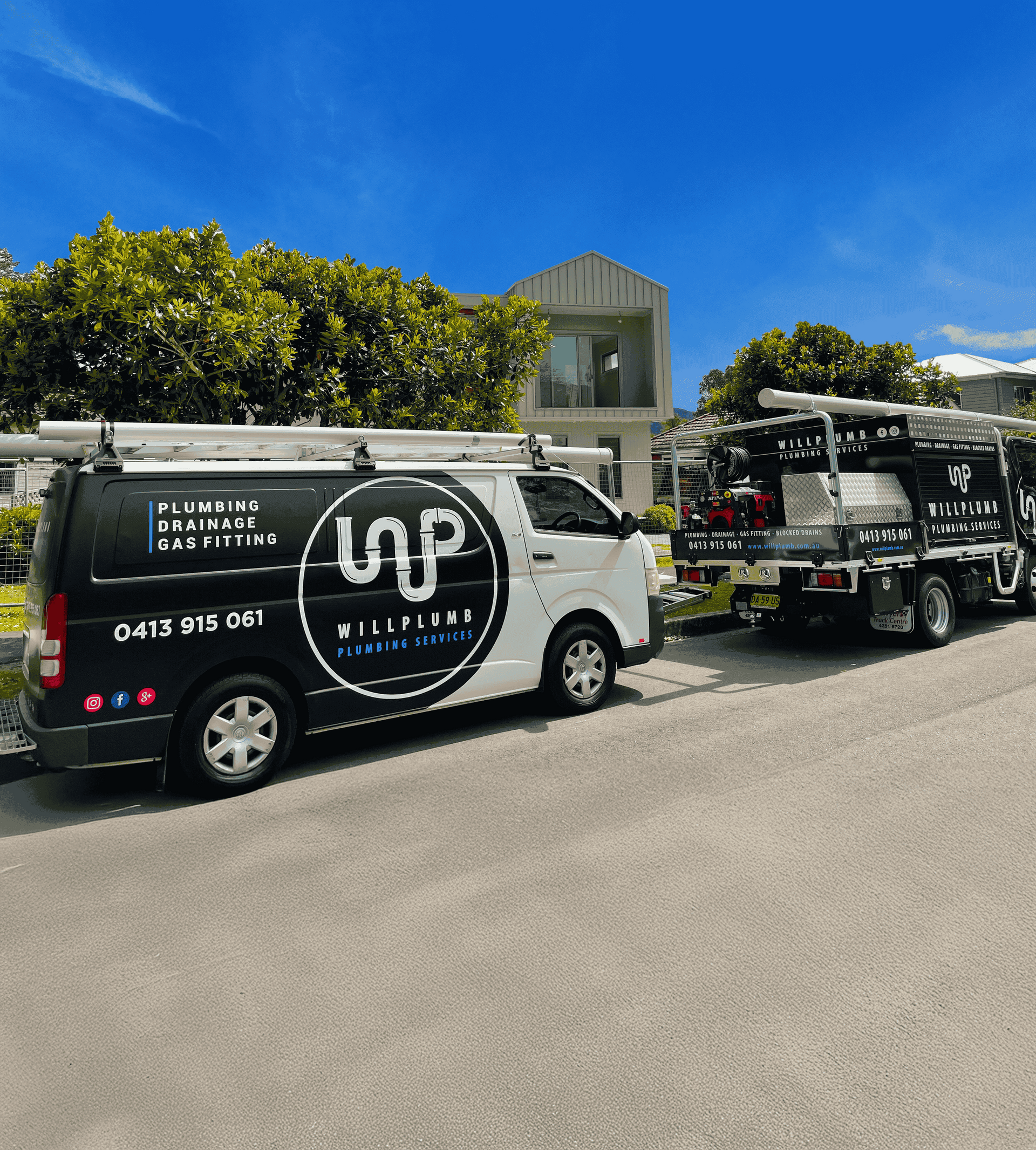 A white van and a utility truck parked on a street in front of a house, both featuring the