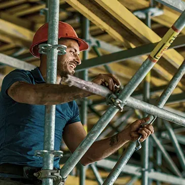 a man wearing a hard hat is working on a scaffolding.