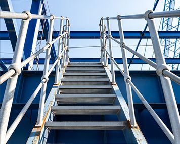 A set of metal stairs leading up to a blue building.