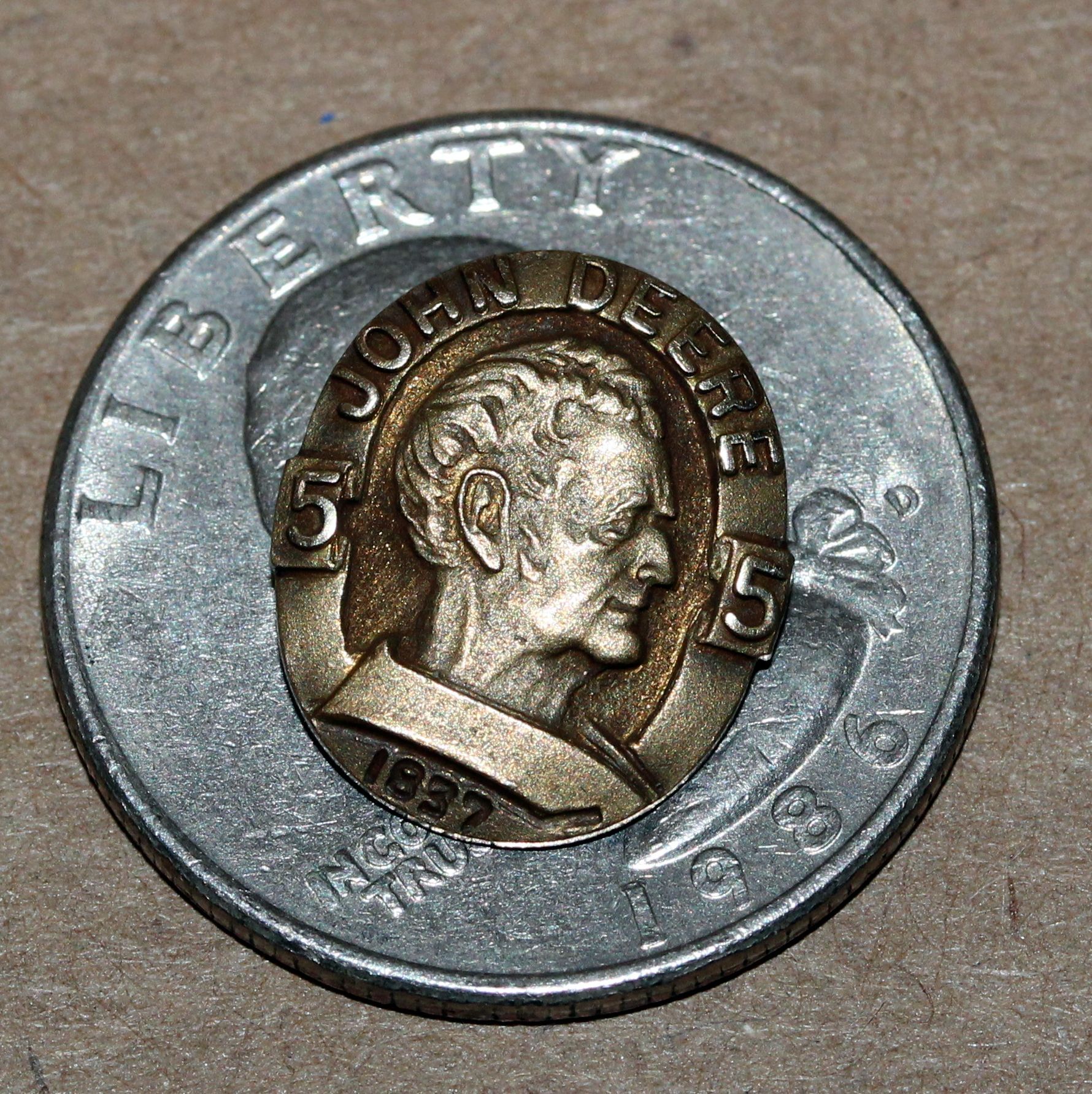 John Deere pin on a dime, featuring a profile portrait and 