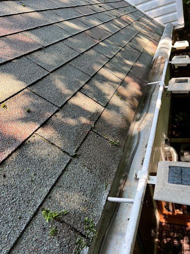 A close up of a gutter on a roof of a house.