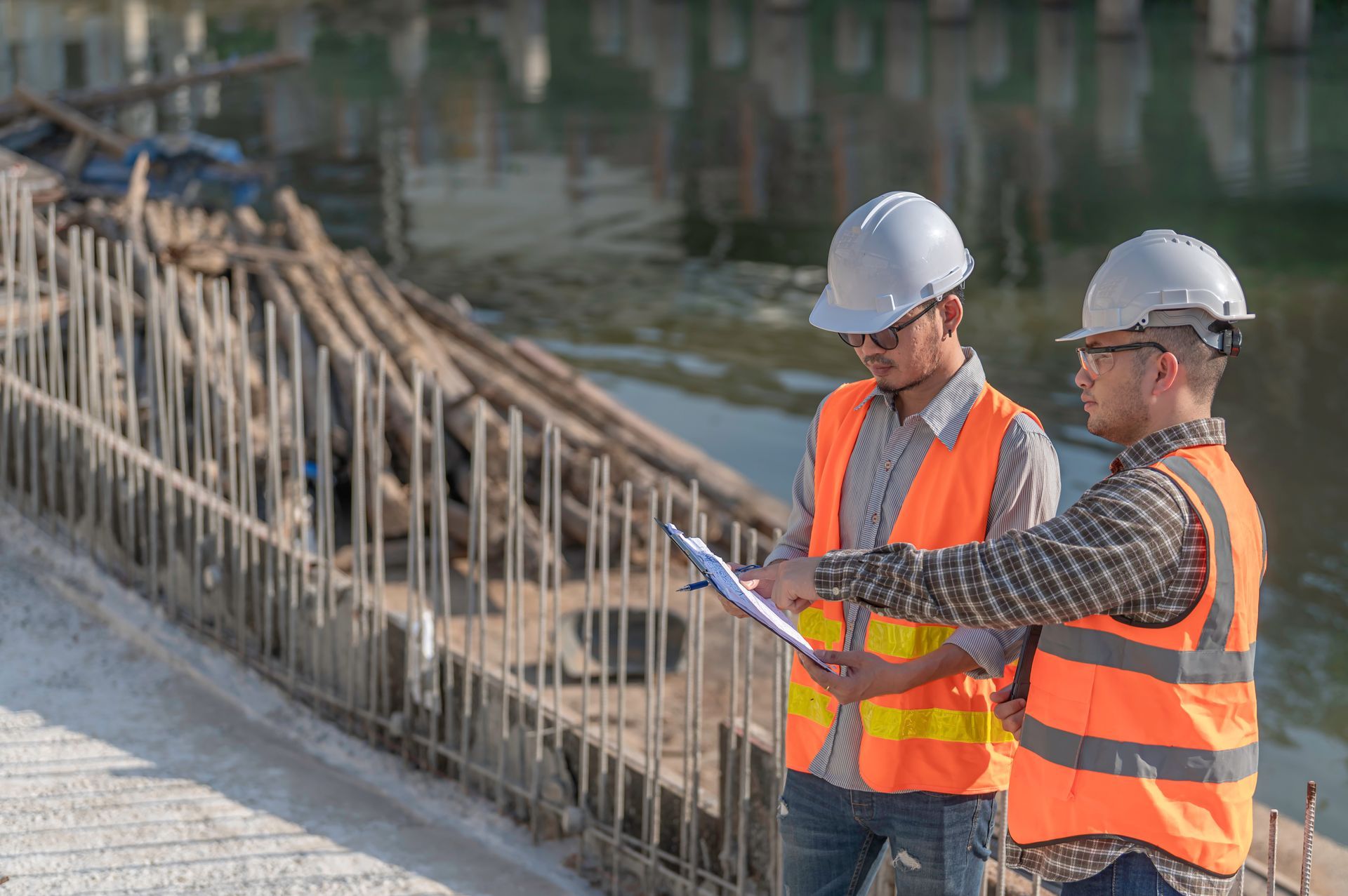 Deux ouvriers du bâtiment regardent un presse-papiers sur un chantier de construction.