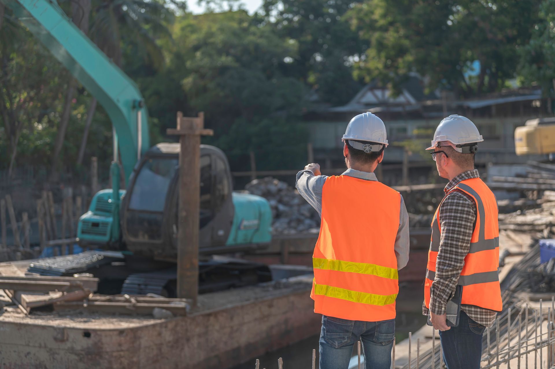 Deux ouvriers du bâtiment se tiennent devant un chantier de construction.