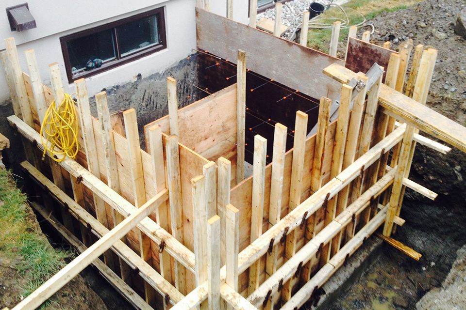 Une structure en bois est en construction devant une maison