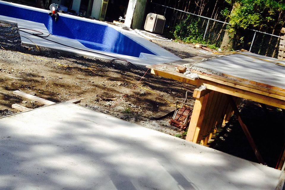 Un chantier avec une piscine bleue en arrière-plan