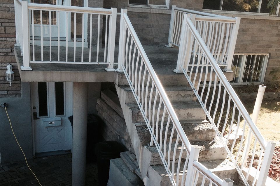 Un escalier menant à un balcon avec une balustrade blanche.