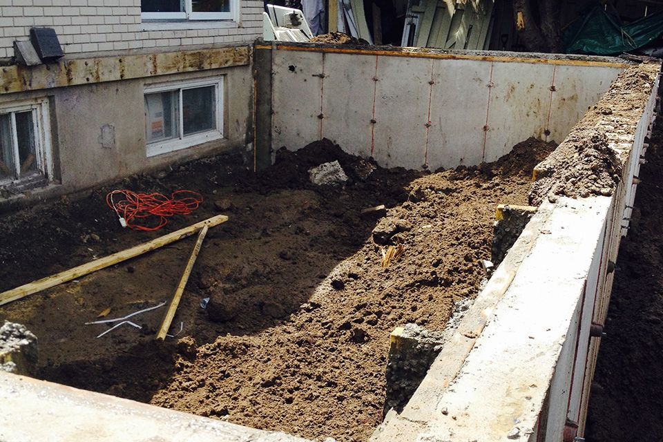 Un mur de béton est en train d'être construit devant une maison.