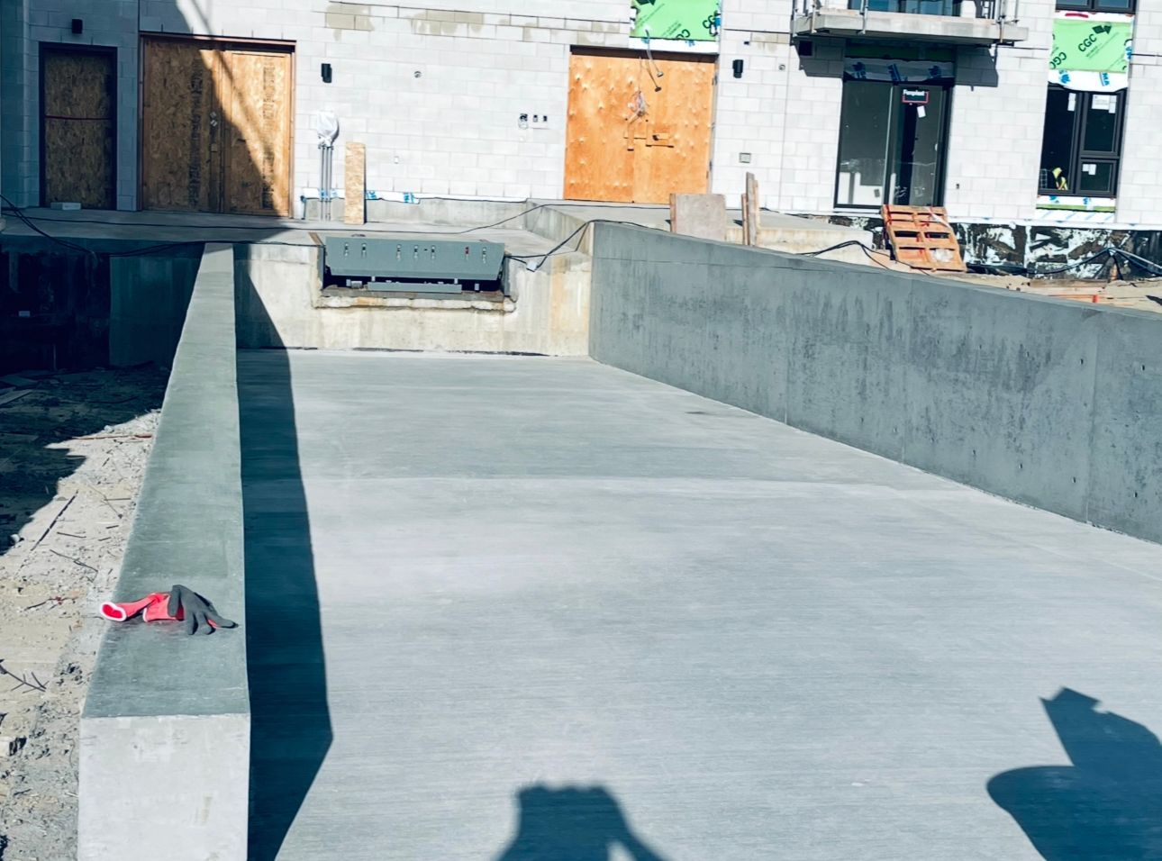 Une passerelle en béton est en cours de construction devant un bâtiment en construction.
