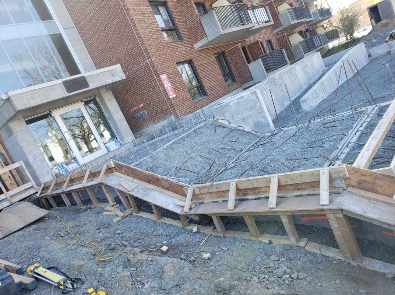 Une rampe en béton est en cours de construction devant un bâtiment.