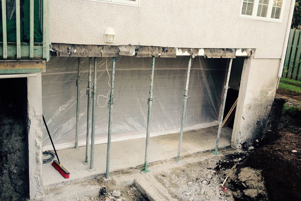 Un balai est posé au sol devant un bâtiment en construction