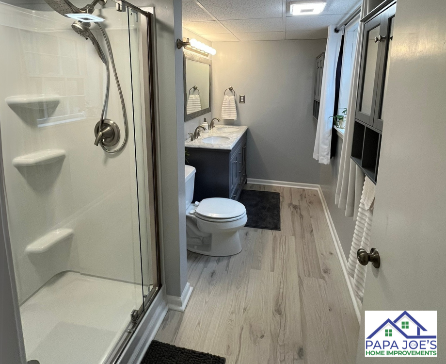 A bathroom with a toilet , sink and shower.