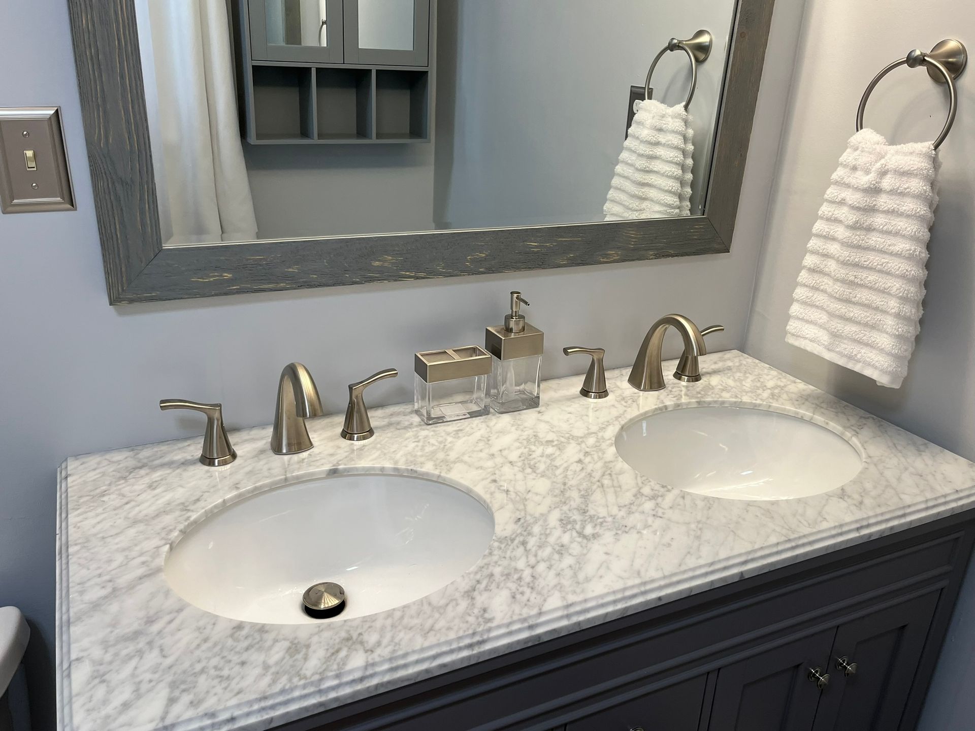 A bathroom vanity with two sinks and a mirror.