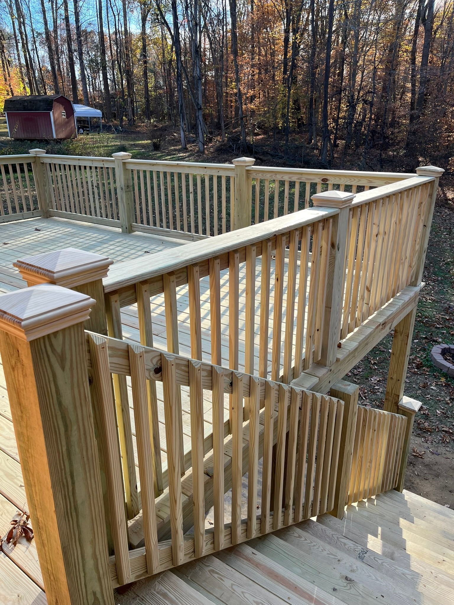 A wooden deck with stairs leading up to it and a wooden railing.