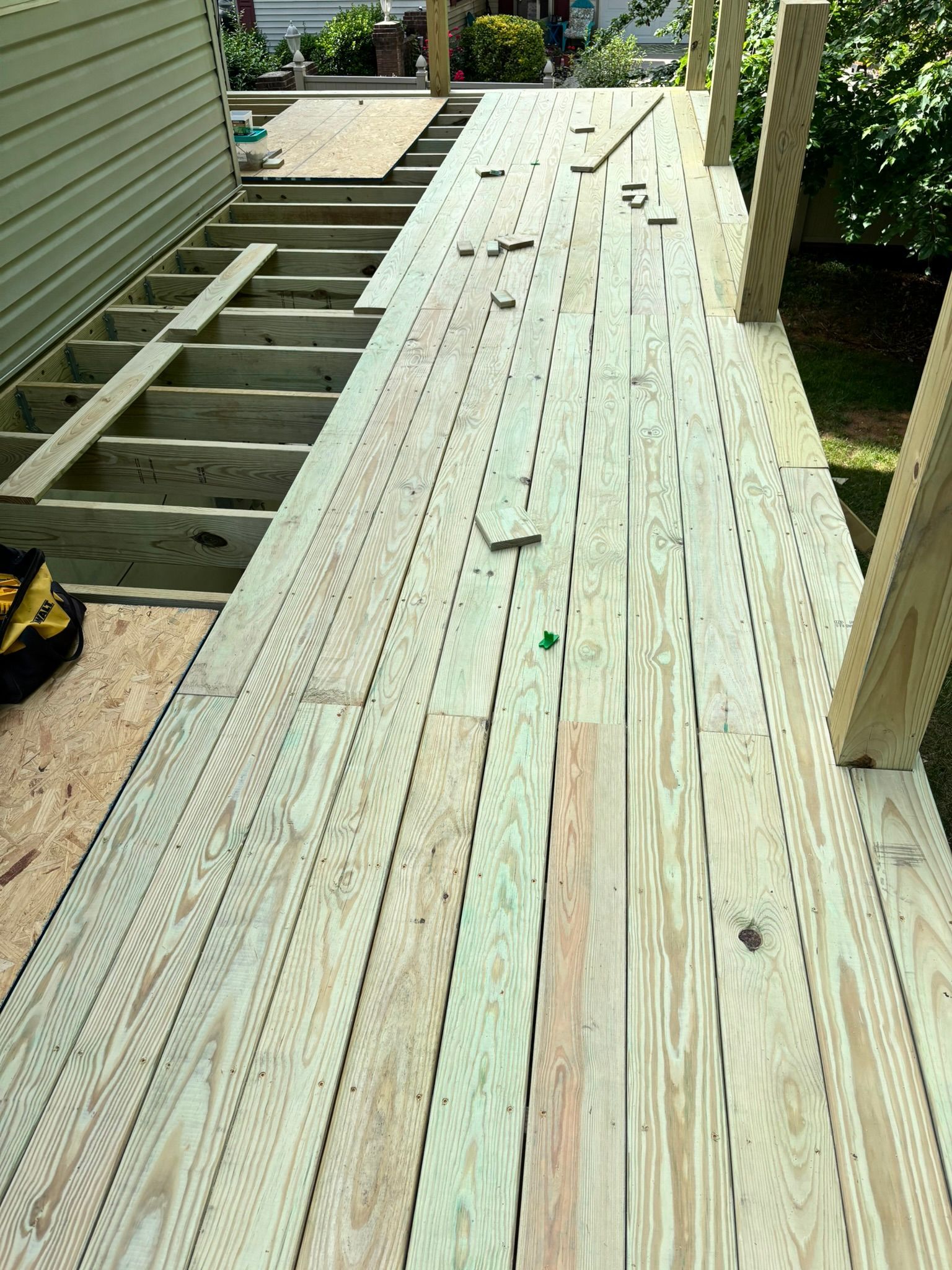 A wooden deck is being built in a backyard.