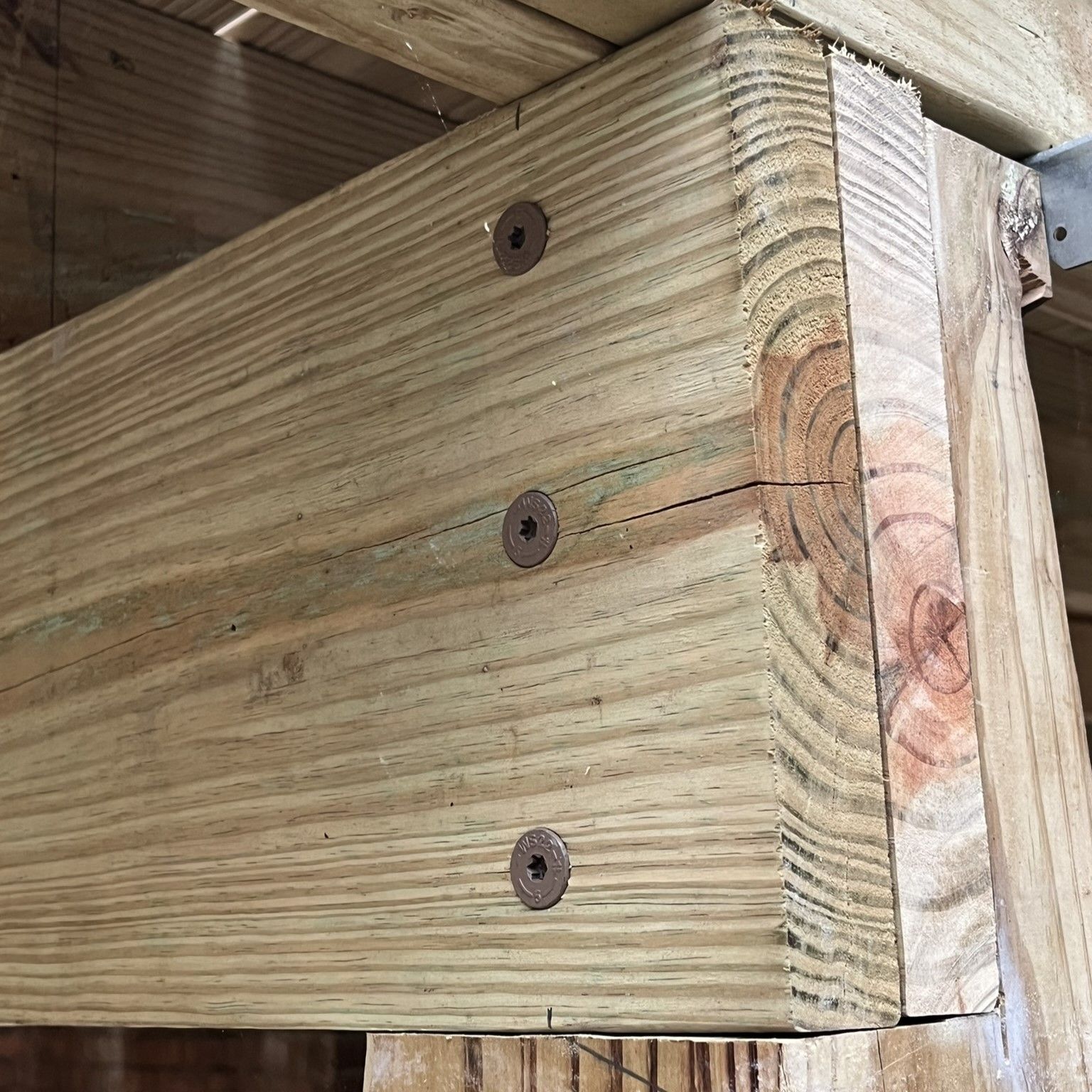 A close up of a piece of wood with screws on it.