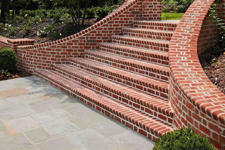 A set of brick stairs leading up to a brick wall.