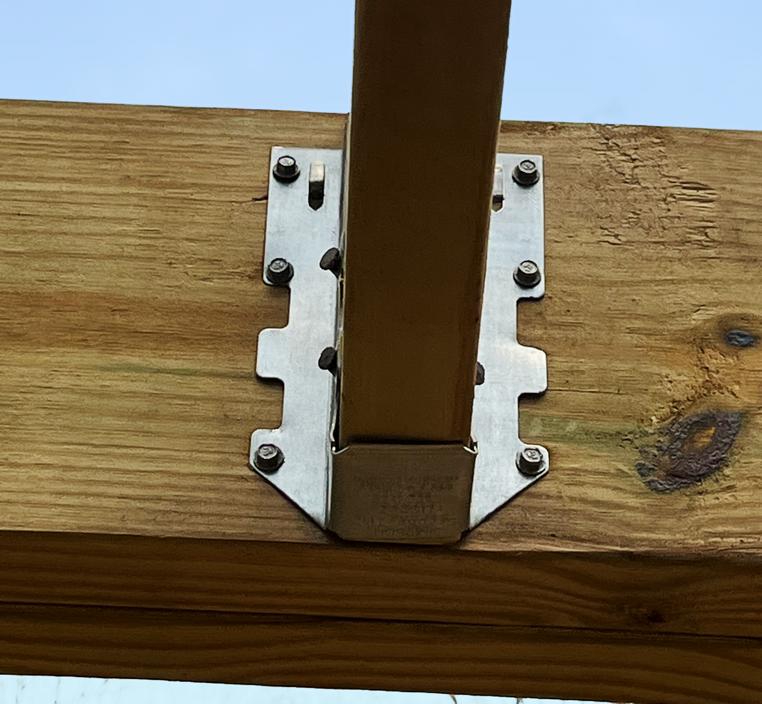 A wooden post with a metal bracket attached to it